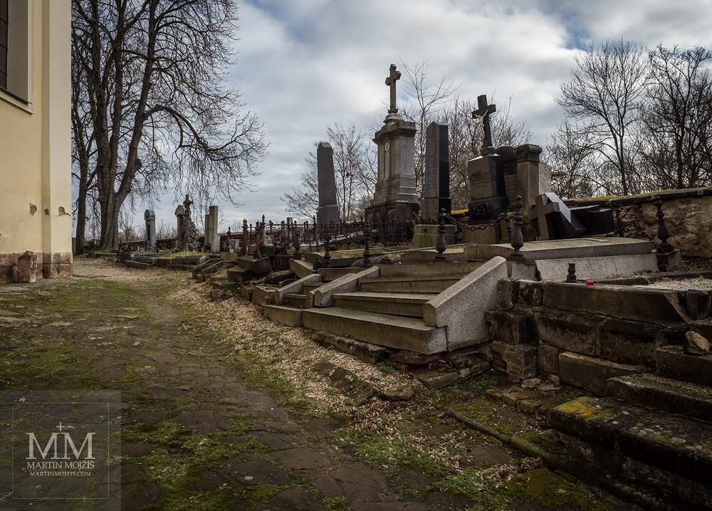 Hřbitov u kostela. Fotografie vytvořena objektivem Olympus 12 - 40 mm 2.8 Pro.